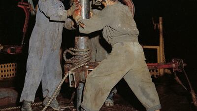 Three local workers prepare the drilling bit for an exploration well at Shuweihat on the Abu Dhabi coast in 1956. Despite reaching a depth of more than 4,000 meters, the well was dry, prompting a return to the Murban Bab field, where commercial quantities of oil were discovered four years later. Photo: Adnoc