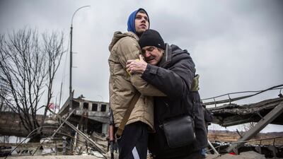 A Ukrainian serviceman comforts a resident who is leaving his home after Russian artillery shelling in Irpin, on the outskirts of Kyiv. AP