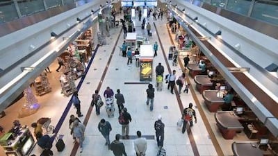 Airline passengers walk between rows of duty free shops in Dubai's Terminal 3.