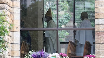 The Archbishop of Cape Town Thabo Makgoba walks in front of the coffin. Reuters