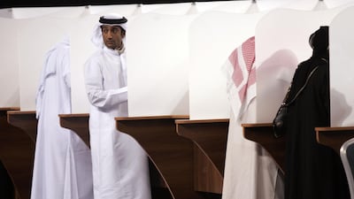 Men and women fill their ballot papers at a polling station in Abu Dhabi. The process has since been made electronic. AFP