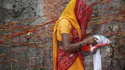 A Hindu woman carrying religious offerings walks past a Kalpavriksha tree, believed to be a divine wishing tree, during a festival on the outskirts of Ajmer. Himanshu Sharma / Reuters