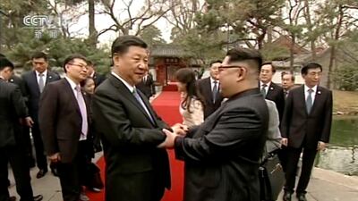 North Korean leader Kim Jong Un, right, and Chinese counterpart Xi Jinping, left, shake hands at Diaoyutai State Guesthouse in Beijing. CCTV via AP Video