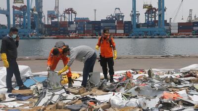 Investigators examine parts of the crashed plane. AP Photo