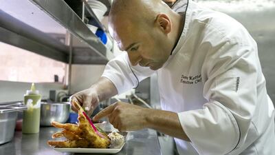 Chef Danny Kattar from InterContinental Abu Dhabi preparing coconut breaded shrimp with peanut sauce. Mona Al Marzooqi / The National