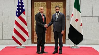 Syria's President Ahmad Al Shara greets Tom Barrack in Damascus on Thursday. Sana via AP