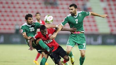 Ismaeel Al Hamadi, centre, of Al Ahli is tackled by Mahmood Qassim, left, and Azizbek Haydarov of Al Shabab during their Arabian Gulf League match at Rashid Stadium in Dubai on September 21, 2014. Ashraf Al Amra / Al Ittihad