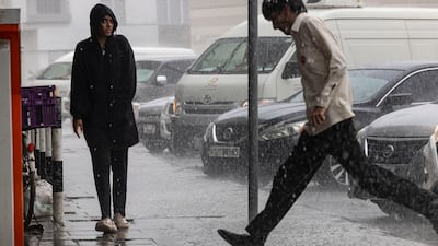 Some residents who braved the rain in Sharjah City chose to move as fast as they could through the raindrops. Antonie Robertson/The National