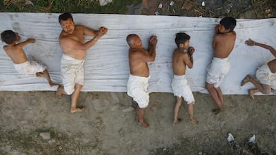 Nepalese Hindus roll on the ground before taking a holy bath in the Hanumante River during the final day of the month long Madhav Narayan fasting festival, in Bhaktapur. Narendra Shrestha / EPA