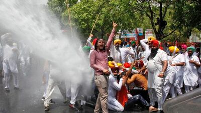 Farmers shout slogans as police use a water cannon to disperse them during a protest in Chandigarh. Ajay Verma / Reuters