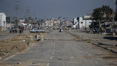 Palestinians move along Salah Al Din road after an Israeli air strike on Al Maghazi refugee camp. EPA
