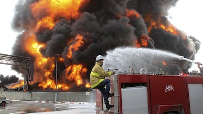 A Palestinian firefighter works during efforts to extinguish a fire at Gaza's main power plant, which witnesses said was hit in Israeli shelling, in the central Gaza Strip July 29, 2014. Israel's military pounded targets in the Gaza Strip on Tuesday after Prime Minister Benjamin Netanyahu said his country should prepare for a long conflict in the Palestinian enclave, squashing any hopes of a swift end to 22 days of fighting. Witnesses said the fuel storage at Gaza's main power plant was struck, sending thick black plumes of smoke up into the air and leaving Gaza City and many other areas in the battered enclave without electricity. Israel launched its offensive on July 8 saying it wanted to halt rocket attacks by Hamas and its allies. REUTERS/Ahmed Zakot (GAZA - Tags: POLITICS CIVIL UNREST)