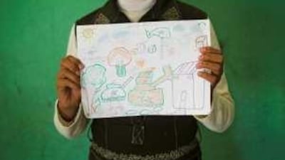 A Palestinian schoolgirl whose younger brother was killed during Israel's latest incursion into Gaza holds a picture she drew.