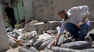 Hazem Abu Murad, head of field operations in Gaza’s police bomb squad, examines a collection of unexploded Israeli munitions at a police station in Nuseirat in central Gaza on August 7, 2014. Heidi Levine for The National