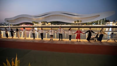 Ukrainian residents and their families hold hands in solidarity at the Ukrainian Independence day celebration in Abu Dhabi