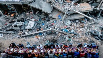 Palestinian families break their fast next to a destroyed building during recent confrontations between Hamas and Israel in the Gaza Strip. AFP