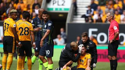 Wolverhampton Wanderers' Irish defender Matt Doherty, centre, receives treatment on the pitch. AFPs. /