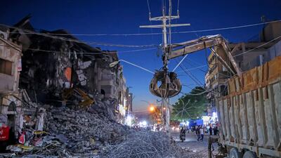 An excavator clears the rubble and debris in the Al Rimal neighbourhood. AFP