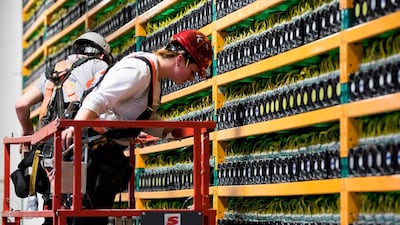 Two construction workers at the bitcoin mining company Bifarms in Saint Hyacinthe, Quebec. Bitcoin investors are coming around to regulatory oversight. AFP