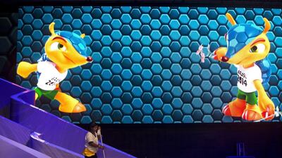 A worker cleans the stage for the 2014 Fifa World Cup draw in Costa do Sauipe, Brazil, on Thursday. On the screen at rear is an image of Fuleco, the World Cup mascot. The draw for the 2014 World Cup finals takes place on Friday. Victor R. Caivano / AP Photo