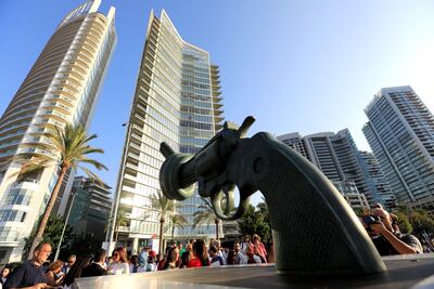 People gather around the copy of Carl Fredrik Reutersward's 'Non-Violence' sculpture during its unveiling ceremony in Beirut, Lebanon. Photo / Reuters
