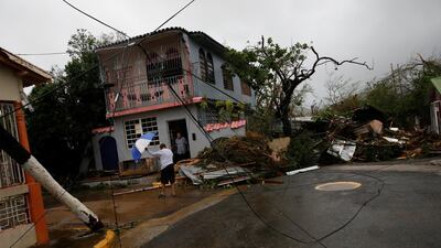 A man walks close to damaged houses after the area was hit by Hurricane Maria in Guayama, Puerto Rico. Carlos Garcia Rawlins / Reuters