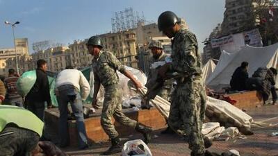 Egyptian soldiers haul away makeshift tents after the army ordered the protesters' encampments closed in Tahrir Square yesterday.