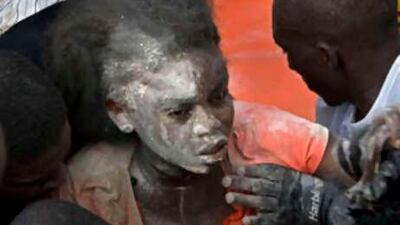 Residents help a woman trapped in the rubble at College La Promesse in Petionville, Haiti, on Nov 7 2008.
