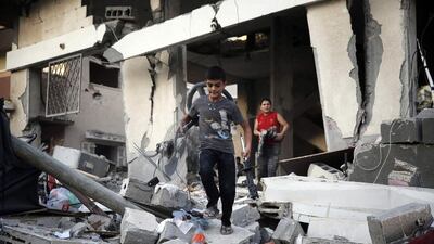 Palestinian boys salvage belongings from a home which police said was targeted in an Israeli air strike, in Gaza last week. Finbarr O'Reilly / Reuters