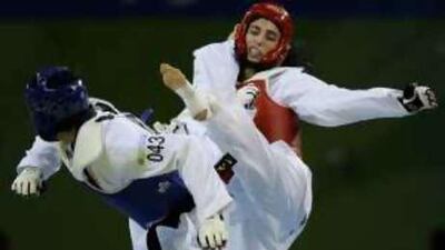 Sheikha Maitha, right, the UAE's final chance of a medal, evades a kick during her 67kg taekwondo first-round defeat to South Korea's Hwang Kyung-seon. After her 5-1 loss she went into the repechage where she was beaten 4-0 by the Croat Sandra Saric.