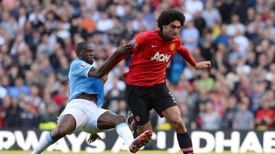Manchester United midfielder Marouane Fellaini, right, is tackled by Manchester City's Yaya Toure. Andrew Yates / AFP