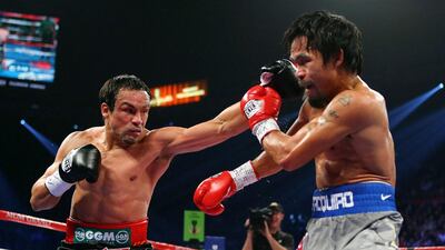 Juan Manuel Marquez, left, throws a left to the face of Manny Pacquiao. Al Bello / Getty Images