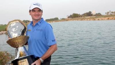 epa03093048 Paul Lawrie of Scotland holds his trophy after winning The Commercial bank Qatar Masters at The Doha Golf Club in Doha, Qatar, 05 February 2012. EPA/STR *** Local Caption *** 03093048.jpg