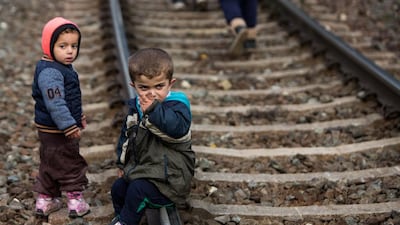 Refugee boys rest on the rail tracks after leaving a refugee camp at the border with Slovenia in Spielfeld, Austria. Vladimir Simicek / AFP Photo