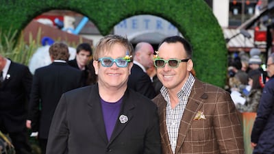 Elton John, in a black suit, purple T-shirt and glittering glasses, and David Furnish attend the premiere of 'Gnomeo And Juliet' at the Odeon Leicester Square on January 30, 2011 in London, England. Getty Images