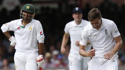 Pakistan’s Sarfraz Ahmed, left, looks on as England’s Chris Woakes, right, celebrates his ninth wicket, Pakistan’s Asad Shafiq, bowled for 49 runs on the third day of the first Test cricket match between England and Pakistan at Lord’s in London, on July 16, 2016. Ian Kington / AFP