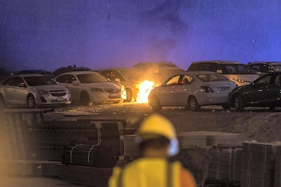 Flaming debris falls in an adjacent informal car park next to the building setting parked cars on fire. Antonie Robertson / The National