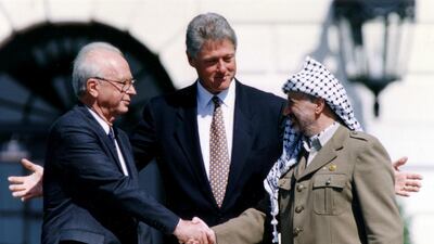 PLO chairman Yasser Arafat shakes hands with Israeli prime minister Yitzhak Rabin, as US president Bill Clinton stands between them, after the signing of the Israeli-PLO peace accord, at the White House September 13, 1993. Reuters