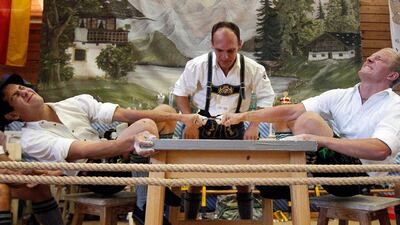 A judge watches two competitors German Finger Wrestling Championships in Warngau, Germany. Competitors, who hold a leather ring with their middle fingers, battled for the title in this traditional rural sport in which the winner has to pull his opponent over the marked line on the table. Matthias Schrader / AP Photo
