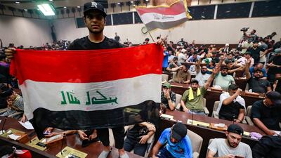 Demonstrators wave Iraqi flags and pictures of Mr Al Sadr inside the legislature. AFP