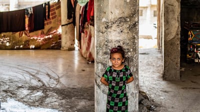 A Syrian girl, displaced with her family from Deir Ezzor, looks at the camera inside the damaged building where she is living in Syria's northern city of Raqqa.