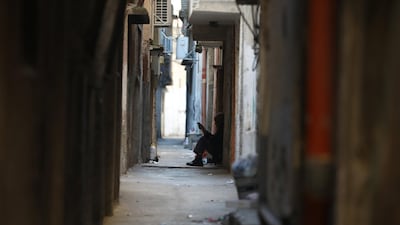 A Palestinian refugee sits outside his home in a narrow street of the Balata refugee camp near the West Bank city of Nablus, on January 9, 2018. US officials said the Trump administration is preparing to withhold tens of millions of dollars from UNRWA. Alaa Badarneh / EPA