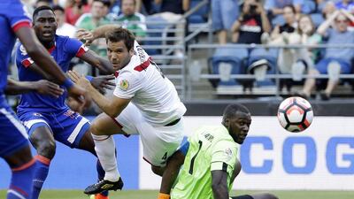 Haiti goalkeeper Johnny Placide, right, eyes the ball as he goes down and Peru defender Renzo Revoredo battles with Haiti midfielder Sony Norde, left, in the second half of a Copa America Centenario match. Peru went on to beat Haiti 1-0. Ted S. Warren / AP Photo