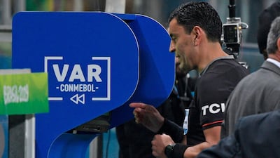 Referee Tobar checks the VAR before showing the red card to Paraguay's Balbuena. AFP