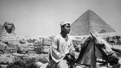 World heavyweight boxing champion Muhammad Ali, who died on June 3, 2016 at the age of 74, seen here wearing tradional ghanaian costume as he rides near the Pyramids of Gizeh, near Cairo in 1964. Ali was on a one-month trip to Africa and Middle East at that time and announced in February 28, 1964 that he was member of the Nation of Islam and converted to muslim faith. AFP Photo