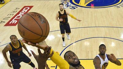 Cleveland Cavaliers forward LeBron James, center, reaches for the ball over the Golden State Warriors during the second half of Game 2 of basketball's NBA Finals in Oakland, Calif., Sunday, June 7, 2015. The Cavaliers won 95-93 in overtime. Bob Donnan/USA TODAY