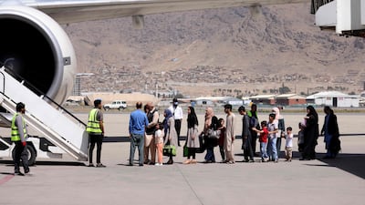 Passengers stand in a queue to board a flight out of the airport in Kabul. AFP
