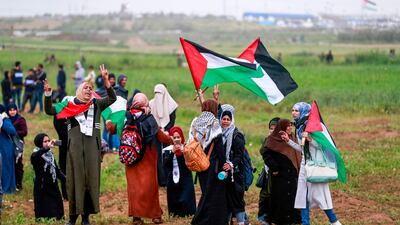 Women protesters flash the victory sign and wave Palestinian flags during a demonstration. AFP