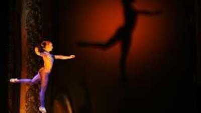 A dancer balances on her partner's hand during the conference's opening ceremony.