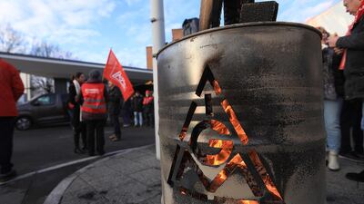The IG Metall logo sits on a burning brazier barrel during a 24 hour strike called by the labor union. As a result, IG Metall workers have secured a pay rise and a cut in working hours. Krisztian Bocsi/Bloomberg